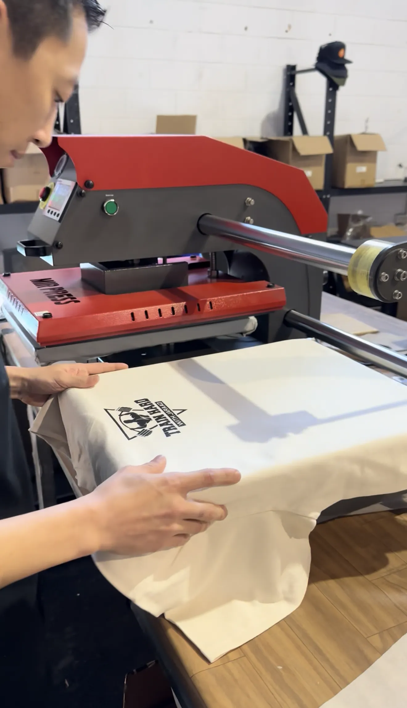 Heat press applying a custom print to a t-shirt at Screenlab